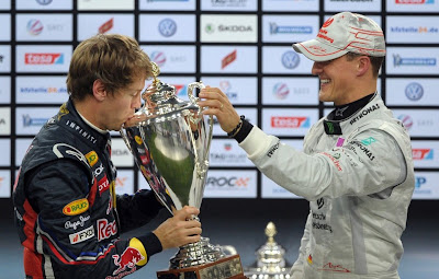 Себастьян Феттель целует победный трофей Гонки чемпионов 2011 из рук Михаэля Шумахера