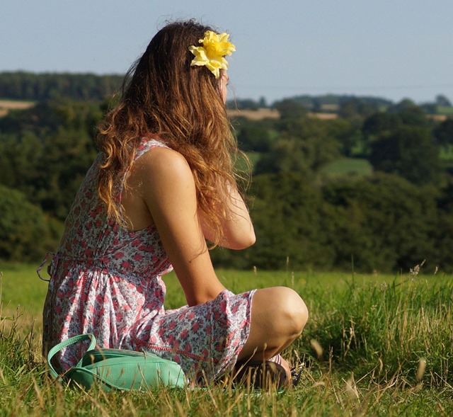 girl sitting in summer meadow