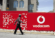 AFFORDABLE: A pedestrian walks past a Vodacom-branded billboard at a taxi rank near Vodaworld. The company has in the past year made it cheaper for customers to make calls