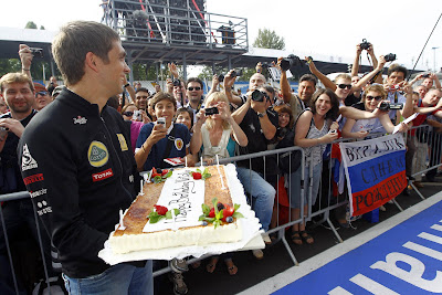 Виталий Петров с праздничным тортом на фоне болельщиков на Гран-при Италии 2011