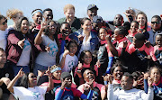 The Duke and Duchess of Sussex with Waves for Change surfers at Monwabisi Beach in Cape Town on September 24 2019.