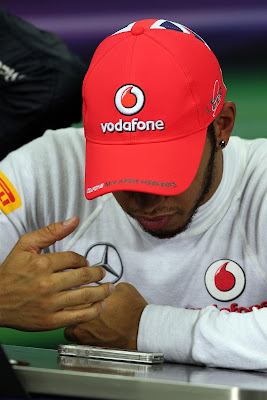 Льюис Хэмилтон смотрит в телефон на пресс-конференции в субботу на Гран-при Кореи 2012