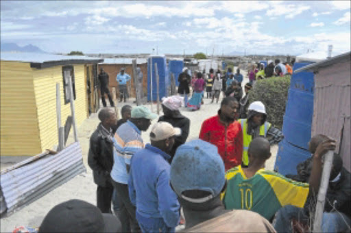 GRUESOME: Nkanini residents stand around Mbongeni Matiti's house (cream shack) after the recovery of four bodies. PHOTO: UNATHI OBOSE