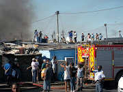 Firefighters battled to reach the flames between the densely packed shacks.