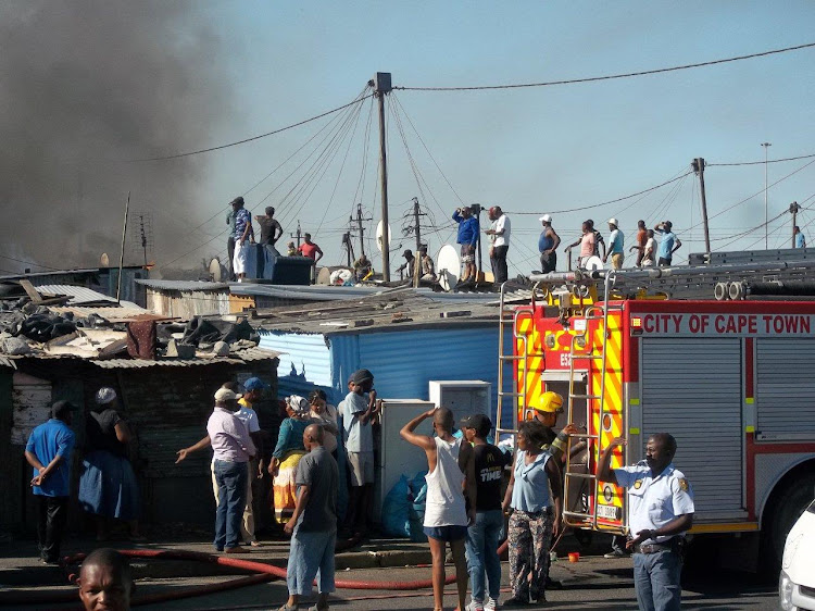 Firefighters battled to reach the flames between the densely packed shacks.