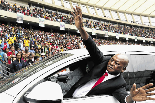 Sam Meyiwa waves to the crowd at his son Senzo's funeral at Moses Mabhida Stadium in Durban yesterday, when thousands of people turned out to bid their hero farewell