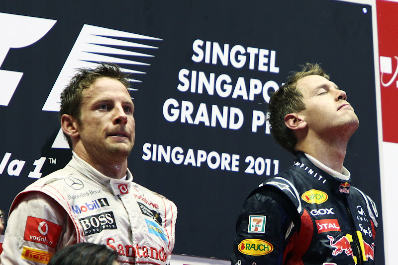 Дженсон Баттон и Себастьян Феттель слушают подиум на подиуме Гран-при Сингапура 2011