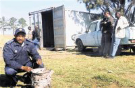 DEADLY GADGET: Captain Shado Mashobane with the brazier the tree dead men are believed to have taken into the container in which they slept. Pic. Len Kumalo. © Sowetan.
