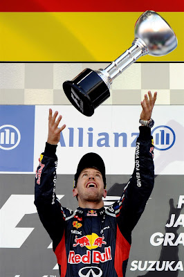 Себастьян Феттель кидает свой трофей в воздух на подиуме Сузуки на Гран-при Японии 2012