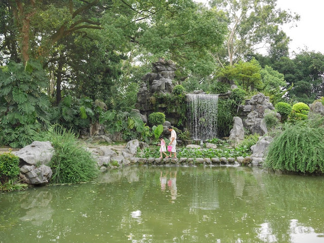 man and small girl walking on small stones across a pond at West Lake in Fuzhou