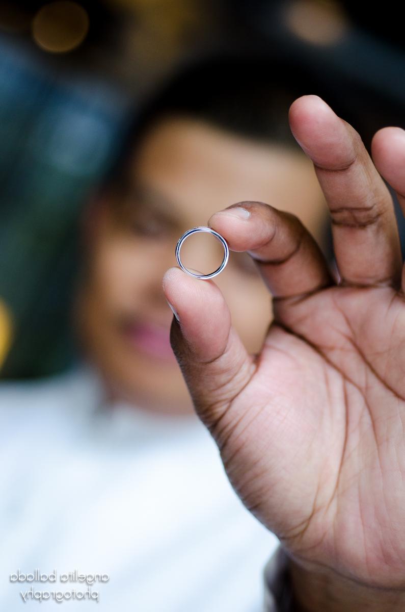 Groom holds wedding ring for