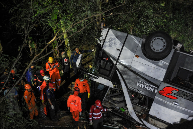 Rescue personnel work at the crash site after a bus fell into a ravine in Sumedang, West Java Province, Indonesia.