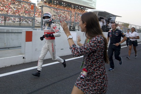 Джессика Мичибата приветствует бегущего по пит-лейну Дженсона Баттона на Гран-при Японии 2011