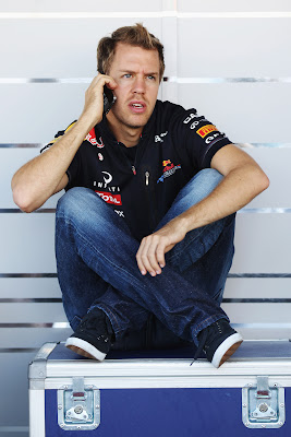 Себастьян Феттель сидит на ящике и разговаривает по телефону на Гран-при Японии 2011