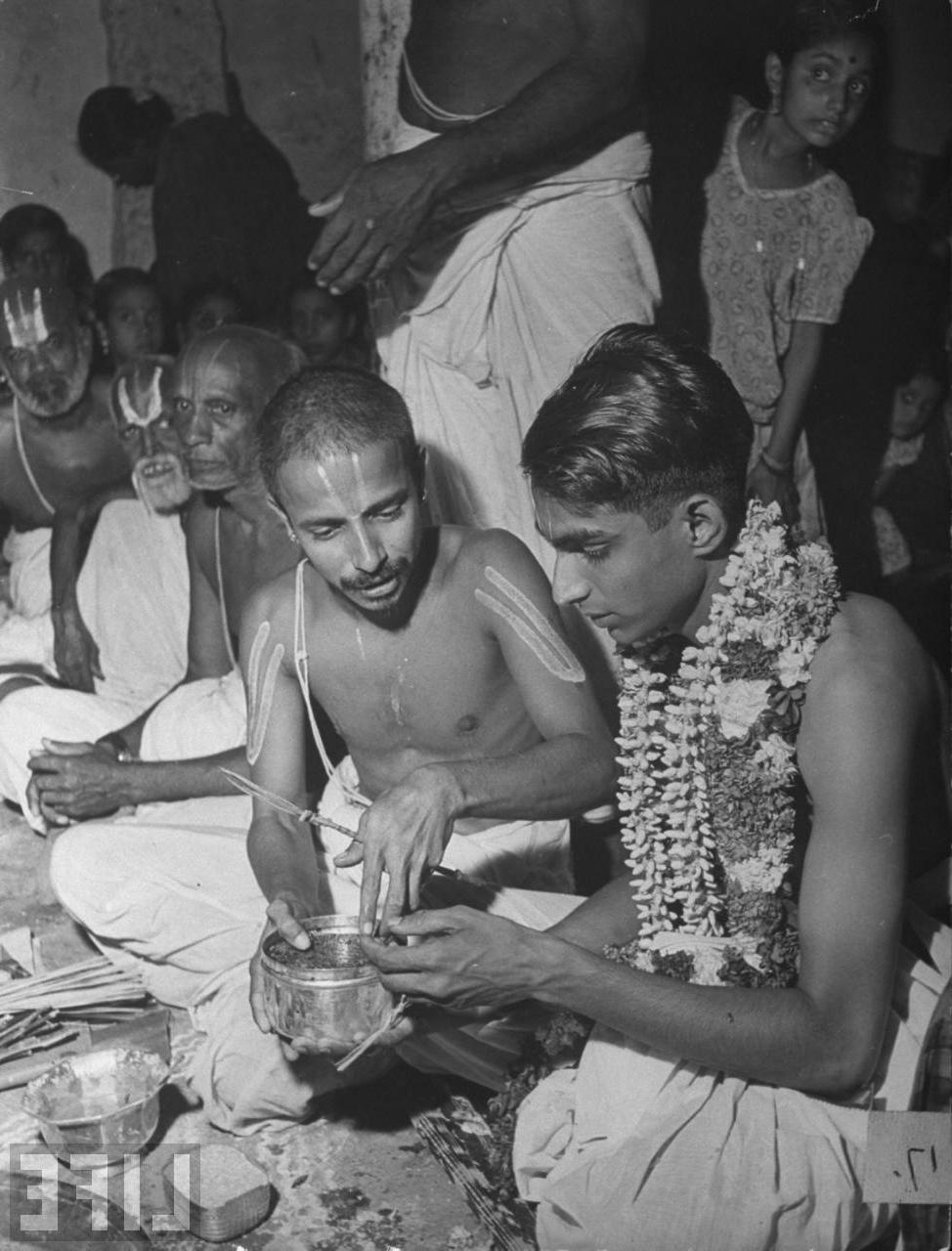 Hindu priest passing a bowl of