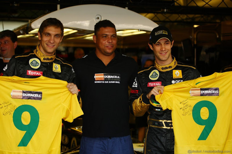 Роналдо в окружении Виталия Петрова и Бруно Сенны с футболками в боксах Lotus Renault на Гран-при Абу-Даби 2011