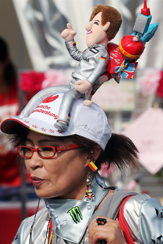 болельщица Михаэля Шумахера с куклой пилота на кепке на Гран-при Японии 2012