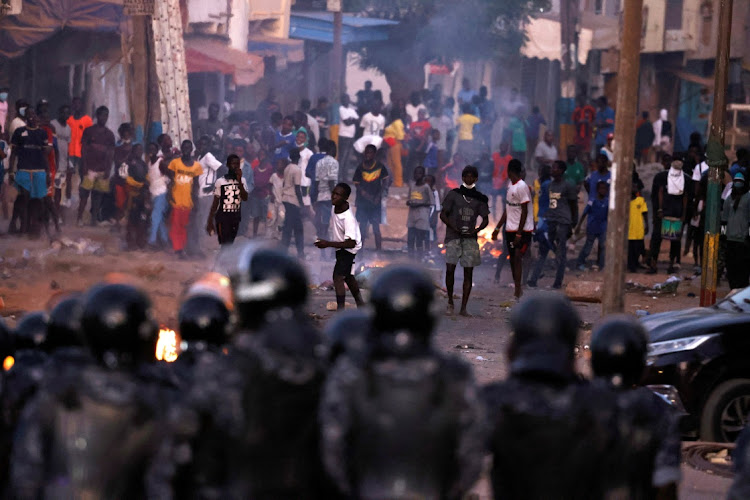 Security forces look at supporters of Senegal opposition leader Ousmane Sonko during clashes after Sonko was sentenced to prison, in Dakar, Senegal, on June 3 2023.