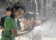 Aziz Taylor, 11, of Washington DC, in the US plays in a fountain to beat the heat gripping the nation's capital