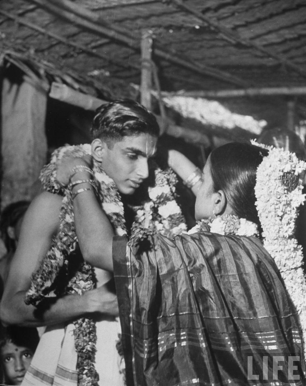 Bride & groom wearing garlands