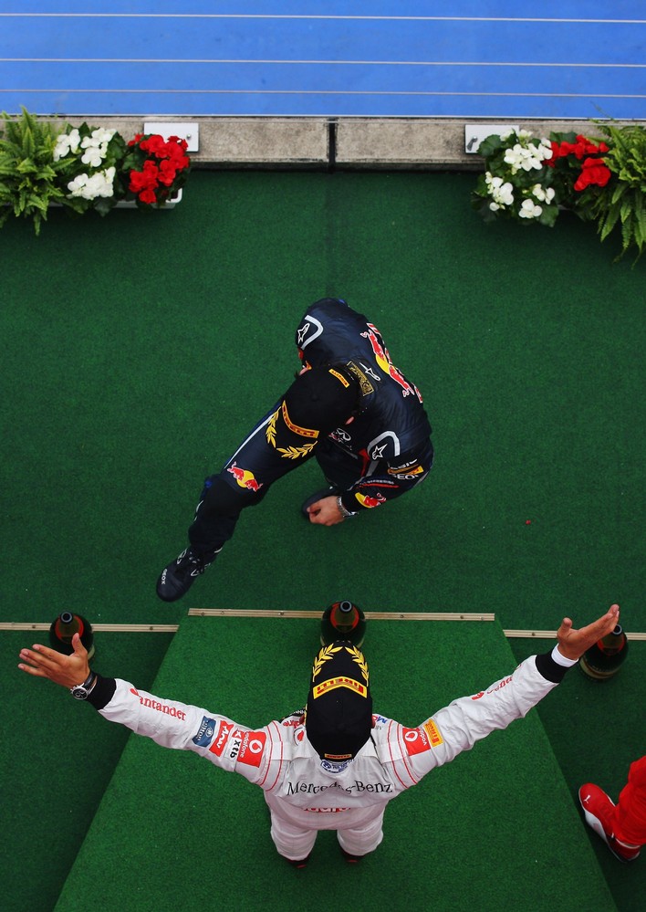 Льюис Хэмилтон раскрывает свои объятия перед Марком Уэббером на подиуме Гран-при Германии 2011