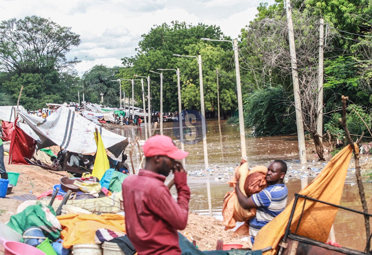 Families affected by floods in Mororo pack along the road after relocating when River Tana burst its banks following heavy rains on April 27, 2024.