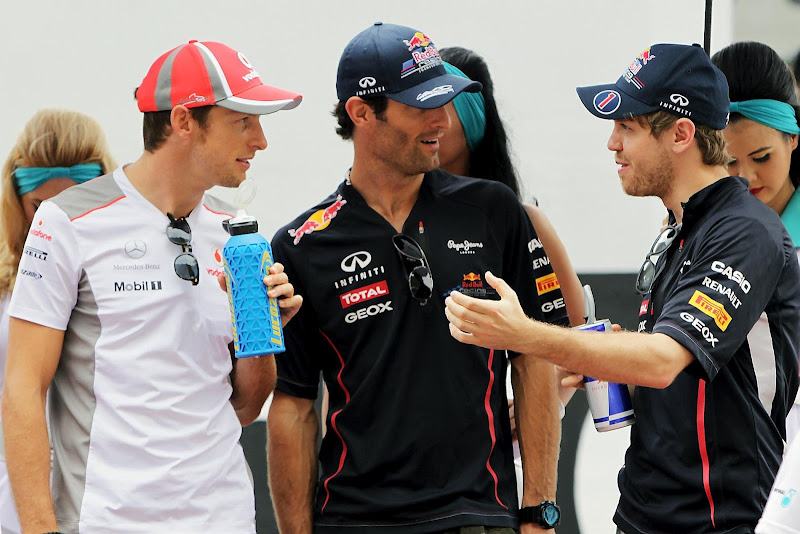 Себастьян Феттель рассказывает что-то Дженсону Баттону и Марку Уэбберу на параде пилотов Гран-при Малайзии 2012