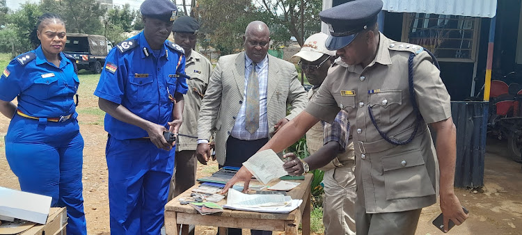 Uasin Gishu police commander Benjamin Mwanthi (2nd from left) with other senior officers sampling some of the items recovered from five suspects found dismantling stolen cars in Eldoret