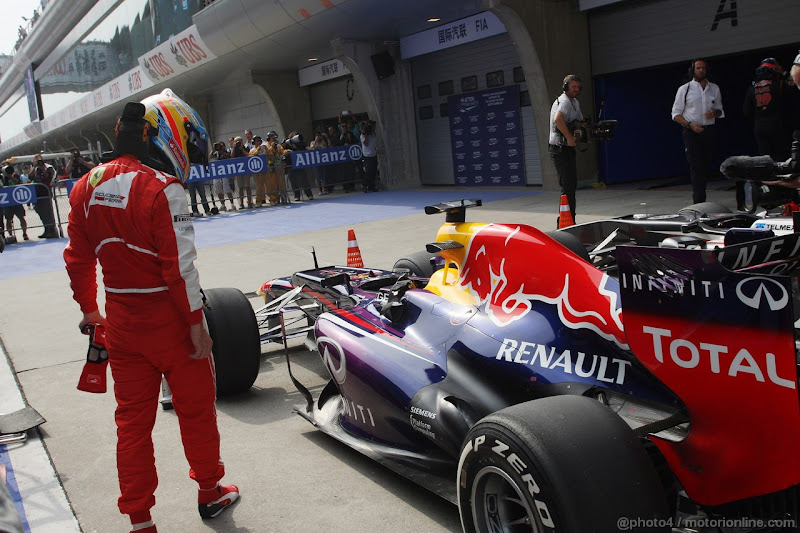 Фернандо Алонсо разглядывает болид Red Bull после квалификации на Гран-при Китая 2013