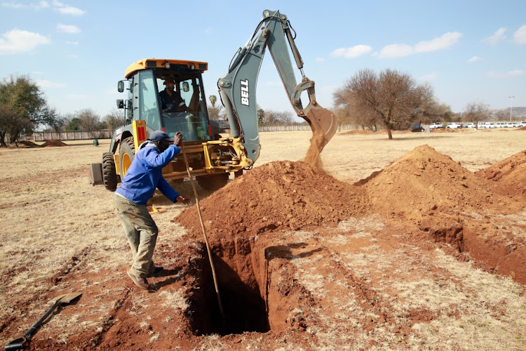Grave diggers seen working during an on-site visit by Dr Bandile Masuku, MEC of health in Gauteng, to the Honingnestkrans cemetery in Tshwane where Covid-19 burials will take place as and when required.