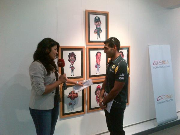 Карун Чандхок дает интервью на фоне плаката VROOOM на Гран-при Индии 2011