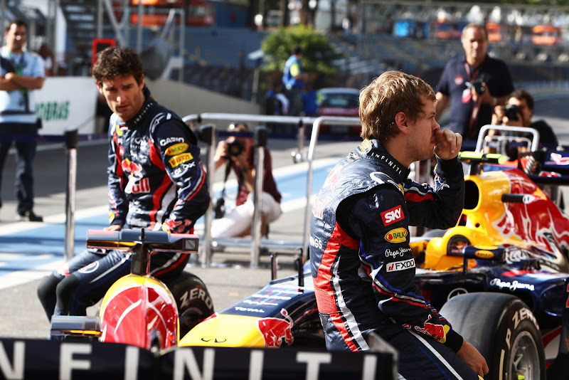 Марк Уэббер и Себастьян Феттель сидят на болидах Red Bull перед своими механиками на Гран-при Бразилии 2011