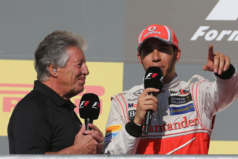 Марио Андретти берет послегоночное интервью у Льюиса Хэмилтона на подиуме Гран-при США 2012