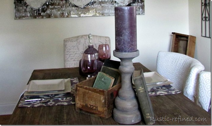 Purple candlestick, antique books and boxes set a pretty summer table