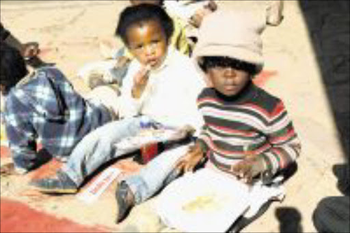 FESTIVE AIR: Children enjoy lunch during the establishment of a vegetable garden at Emma Brosius Crèche on Nelson Mandela Day. Pic: ROBERT MAGWAZA. Circa 2009. © Sowetan