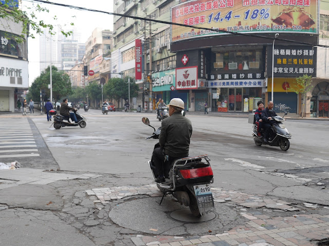 motorbike taxi driver waiting at an intersection in Hengyang, Hunan