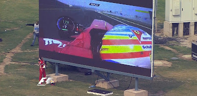 Фернандо Алонсо смотрит повтор тв трансляции на экране автодрома на Гран-при Индии 2011