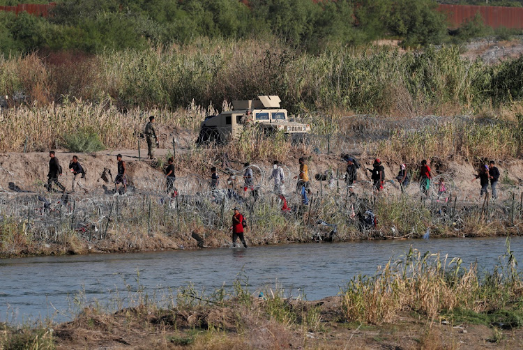 Migrants walk along the banks of the Rio Grande river after crossing in an attempt to seek asylum into the US, as seen from Piedras Negras, Mexico, on September 28 2023. Picture: DANIEL BECERRIL/REUTERS