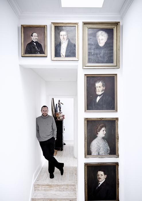 Otto de Jager with his "gallery of instant ancestors" on the staircase landing.