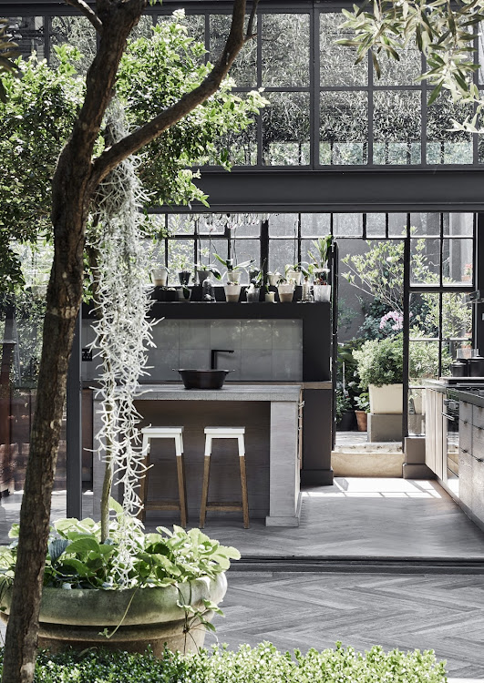 The cottage pane windows and profusion of orchids in the kitchen make it feel a little like a greenhouse or conservatory.