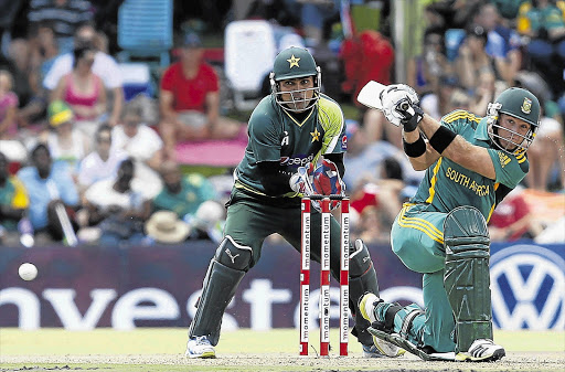 Pakistan wicketkeeper Kamran Akmal, left, watches South Africa's Colin Ingram play a shot on his way to an unbeaten century during the one-day international match in Bloemfontein yesterday