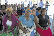 SOLIDARITY: Family members Ester Mamintsa, left, and Elizabeth Mdluli, front centre, pray at Lily mine near Barberton. File photo.