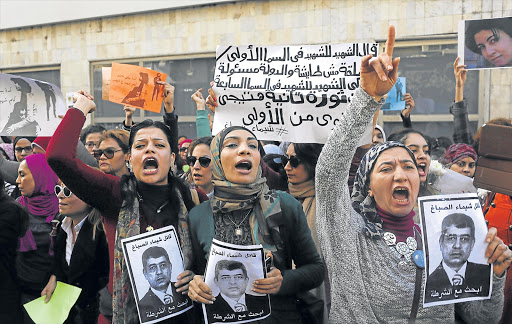 Protesters chant anti-government slogans while holding posters of Egyptian Interior Minister Mohamed Ibrahim with the words, "Wanted, the killer of Shaimaa al-Sabbagh" during a protest by women at the same location in central Cairo