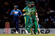 South Africa's Jean-Paul Duminy talks with his teammate Hashim Amla as Sri Lanka's captain Angelo Mathews is seen at the background in Pallekele, Sri Lanka. 