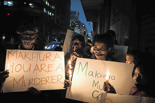 SCANT LIGHT IN THE DARKNESS: Relatives and family members of some of the 94 mentally ill patients who died last year hold a candlelight vigil organised by the DA outside the Gauteng premier's office last week.