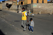 A man and child head to a polling station in Alexandra, Johannesburg. 