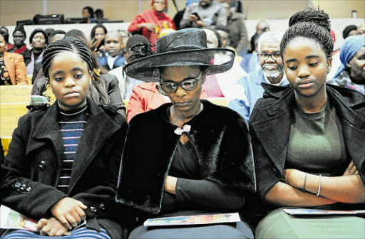 TRYING TIME: Wife Zisiwe Clay is flanked by daughters Sivuyisiwe, left, and Usisipho at a memorial for unionist Makhi Clay in Quigney Picture: RANDELL ROSKRUGE