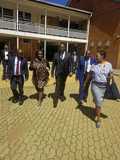 Gauteng education MEC Panyaza Lesufi with his entourage at Three Rivers Secondary School in Vereeniging where a pupil was caught on camera in class throwing an exercise book at her female teacher. /Twitter