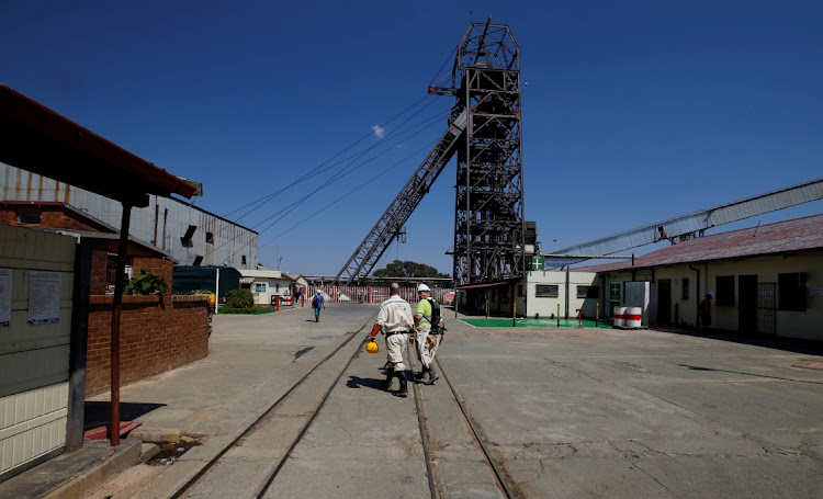 Mine workers walk past the pit head at Sibanye Gold's Masimthembe shaft in Westonaria. Picture: REUTERS/MIKE HUTCHINGS