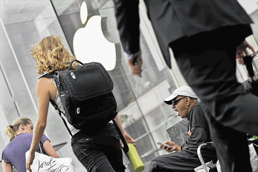 Hazem Sayed yawns while he waits in the queue outside the Apple store on 5th Avenue, New York for iPhone5 models to go on sale. Apple said pre-orders outstripped initial supply Picture: BRENDAN MCDERMID/REUTERS